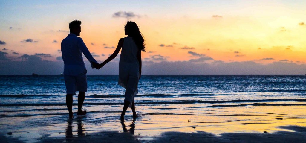 Couple qui se tient par la main sur la plage